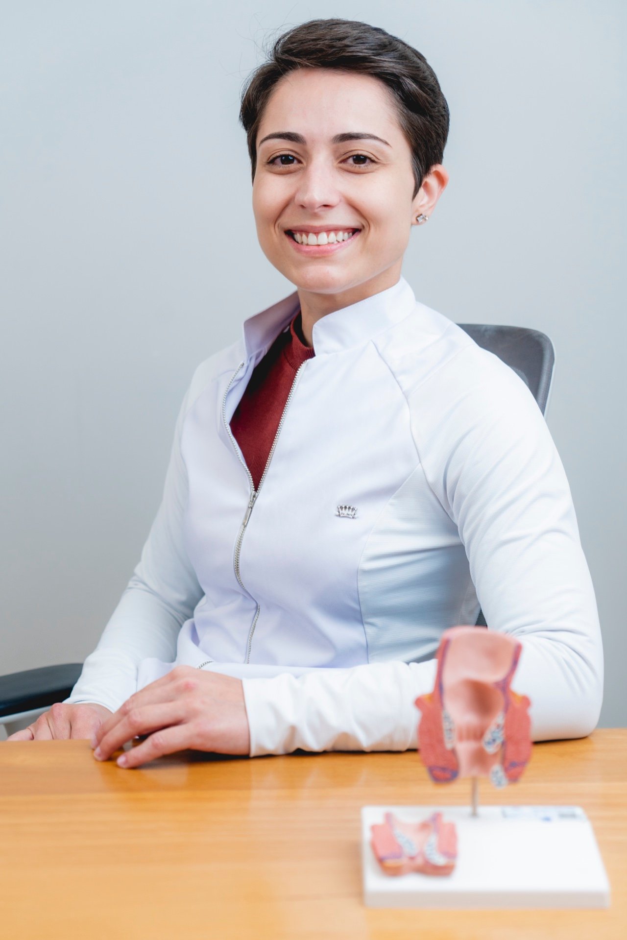Dra. Paola Meinicke, médica coloproctologista, em consultório no Tatuapé com modelo anatômico utilizado em tratamentos com laser